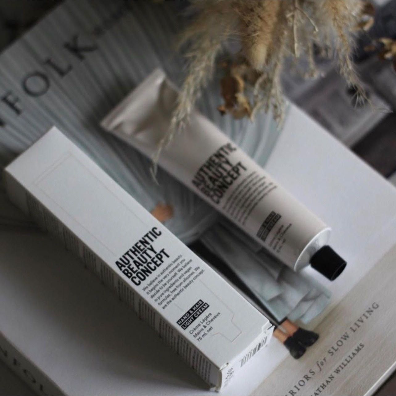 Eine Tube mit authentischem Schönheitskonzept liegt auf einem Buch