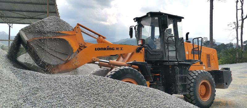 Lonking CDM835A orange front-end wheel loader unloading gravel at a construction site in Dubai UAE