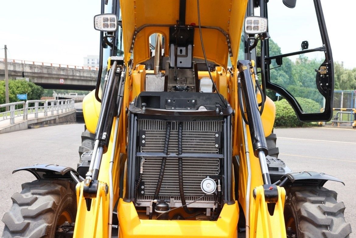 Close-up of Lonking backhoe loader engine bay and radiator during maintenance at Vibranium Machinery Dubai UAE
