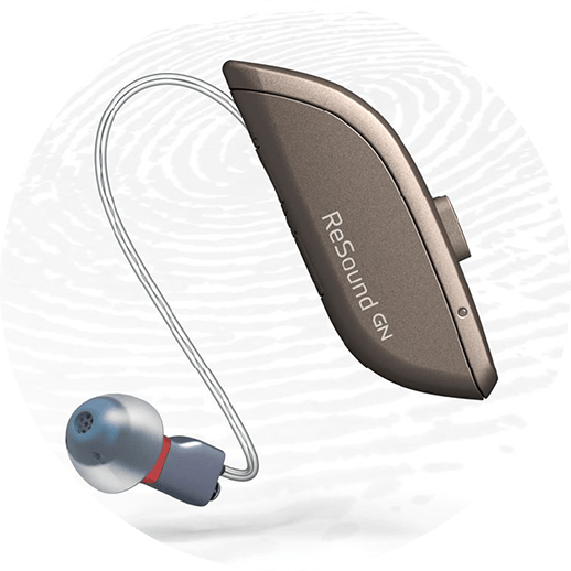 Et høreapparat sidder på en hvid overflade.