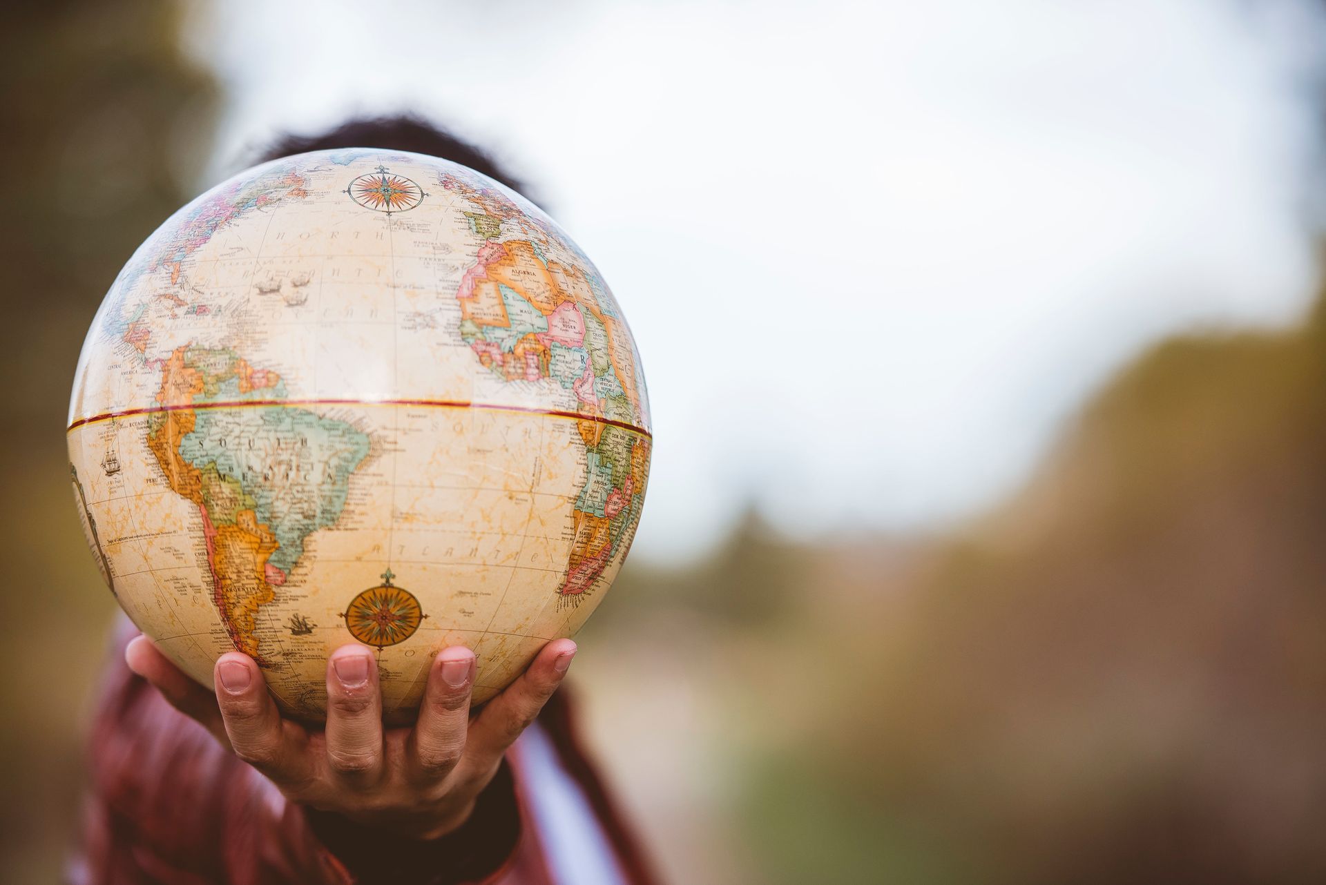 a person is holding a globe in their hands .