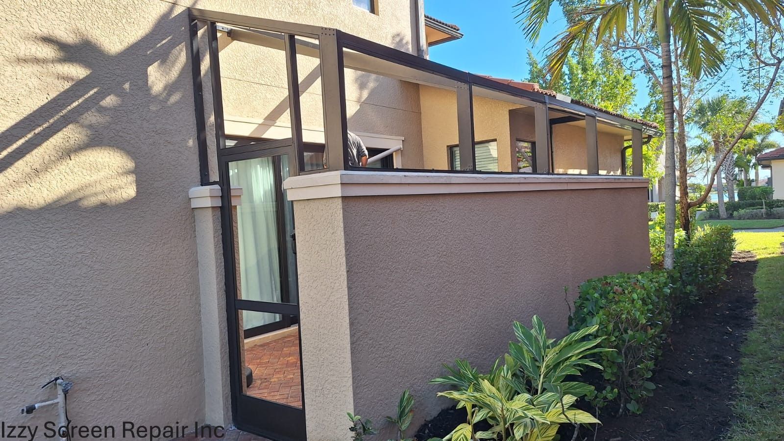 A man is carrying a large piece of metal over his head next to a pool.