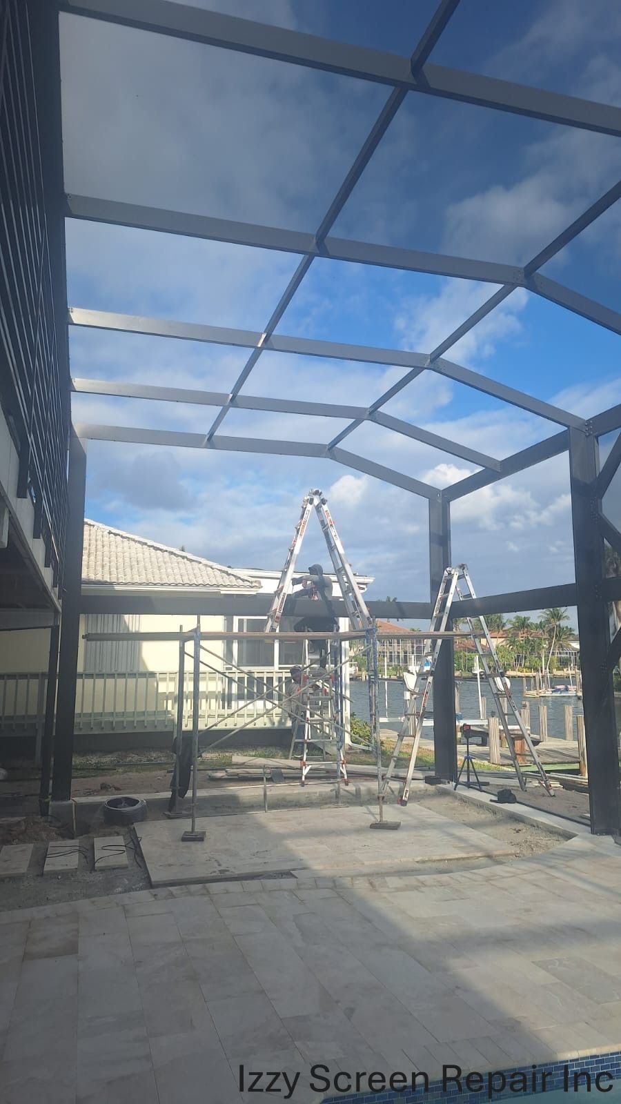 A screened in porch is being built in the backyard of a house.