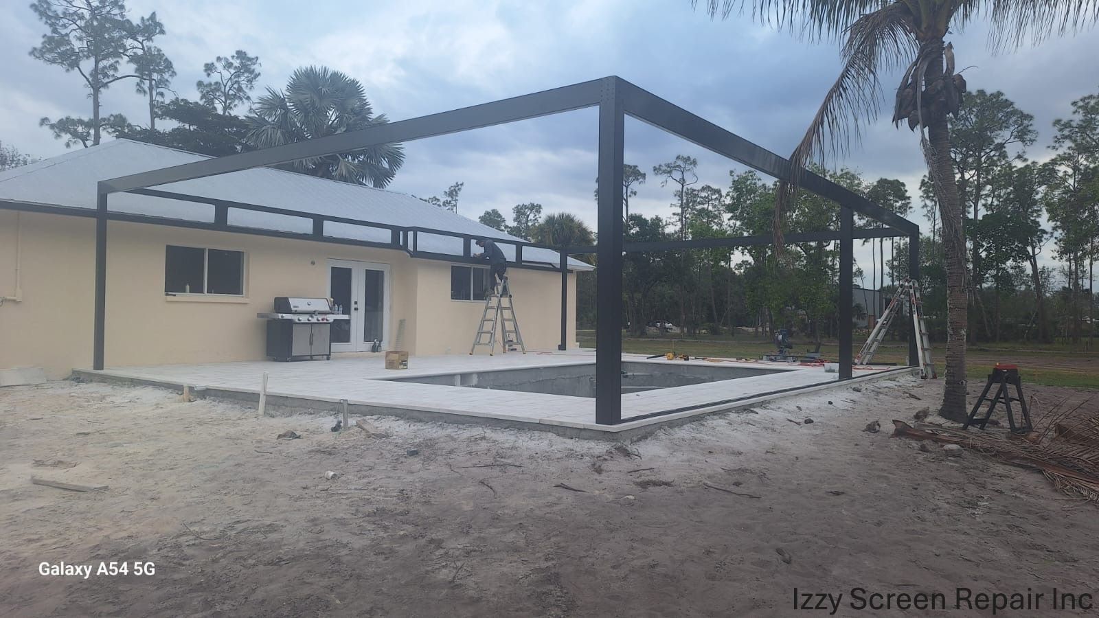 A house with a patio and a pool in front of it.
