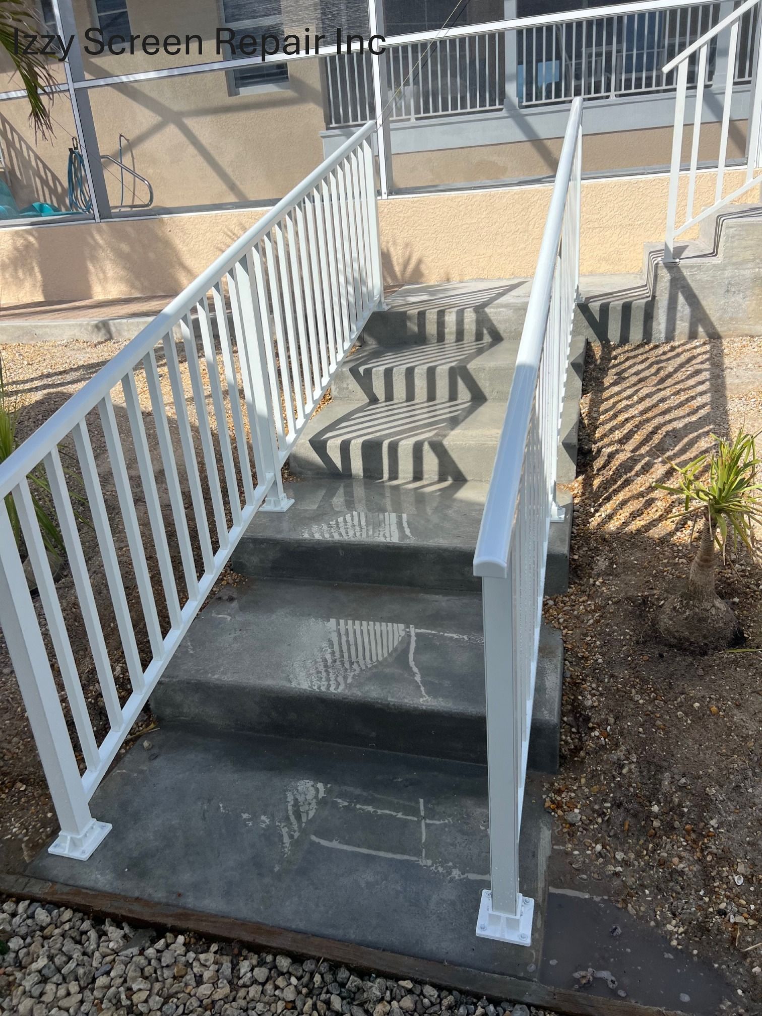 A set of stairs with a white railing leading up to a screened in porch.
