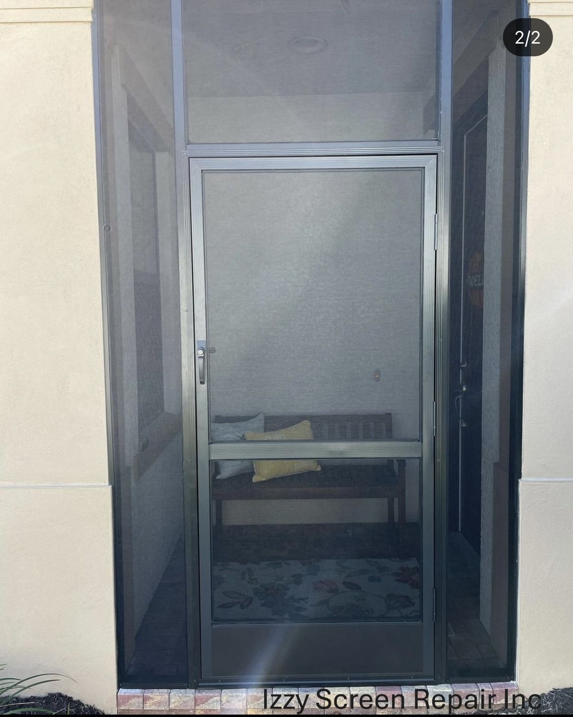 A screen door is open to a room with a bed in it