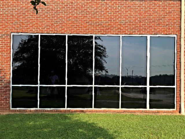 Residential Tinting Tallassee — Tinted Glass Window in Brick Wall Building in Montgomery, AL