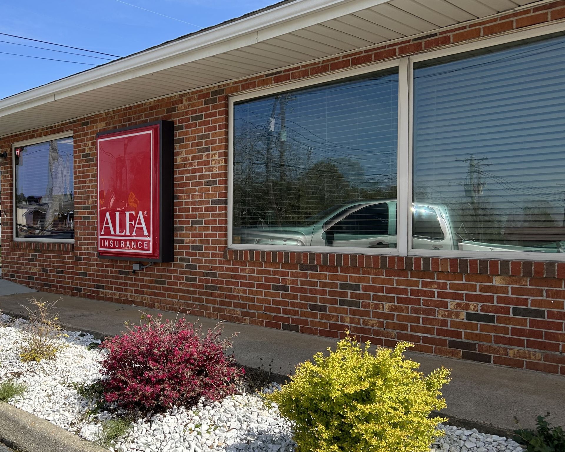 Sun blocking tint adding one-way privacy - bright Sun beamed through the storefront office windows at Alfa Insurance. Prior to SPF Tinting service in Troy, AL