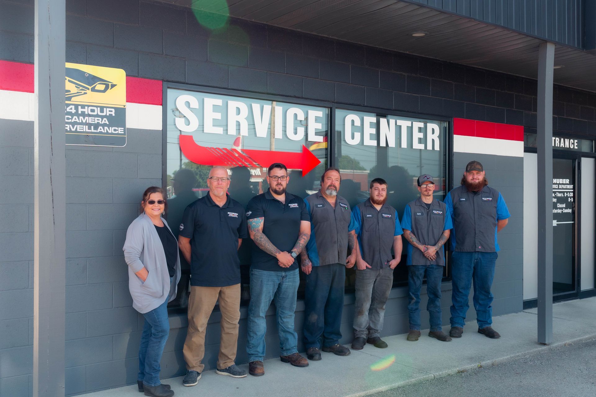 The team at Huber Automotive standing in a line in front of the service center | Huber Automotive