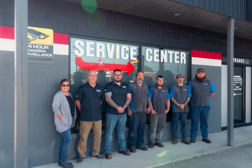 The team at Huber Automotive standing in a line in front of the service center | Huber Automotive