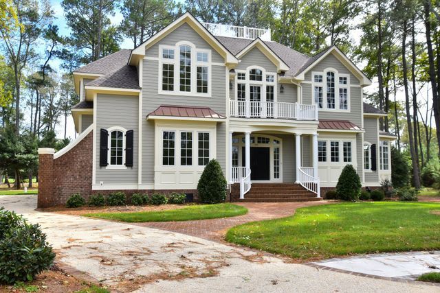 A large house with a lot of windows is surrounded by trees