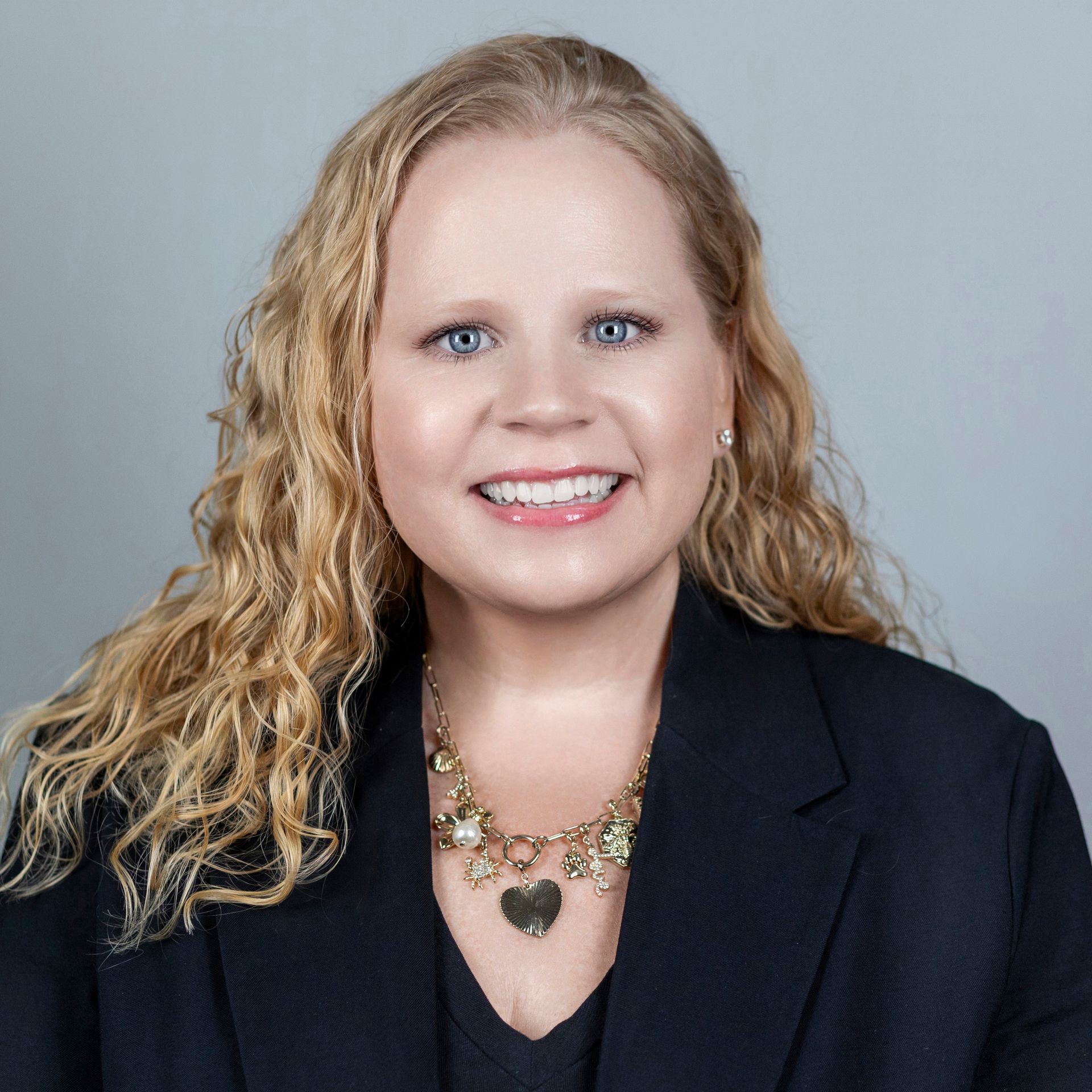 A man with a beard is smiling and wearing a black shirt.