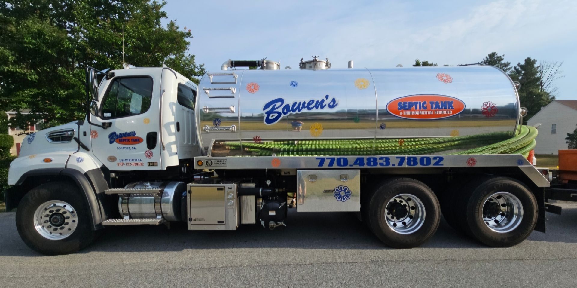 A septic tank truck is parked on the side of the road