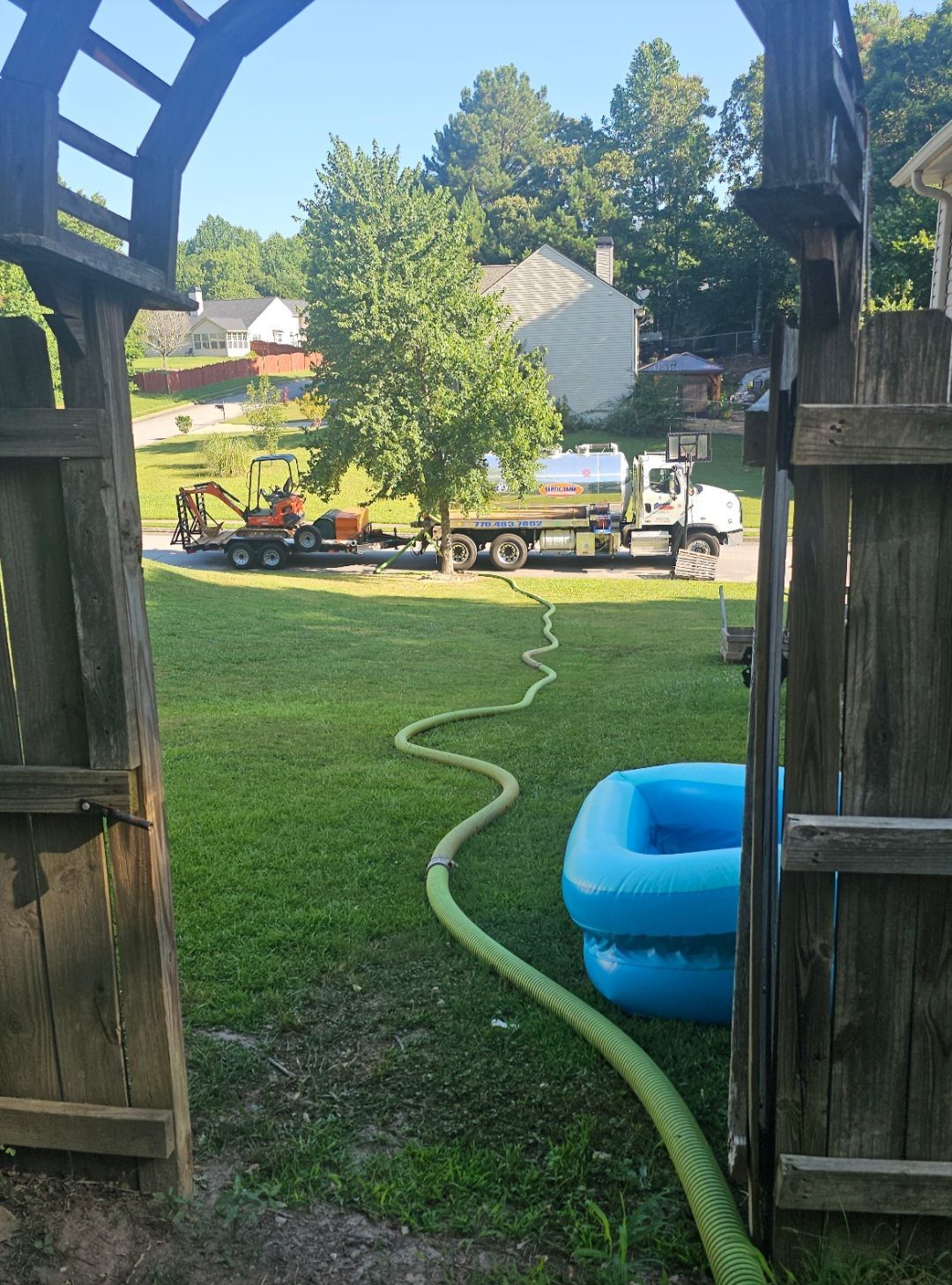 A hose is connected to a truck in a yard.