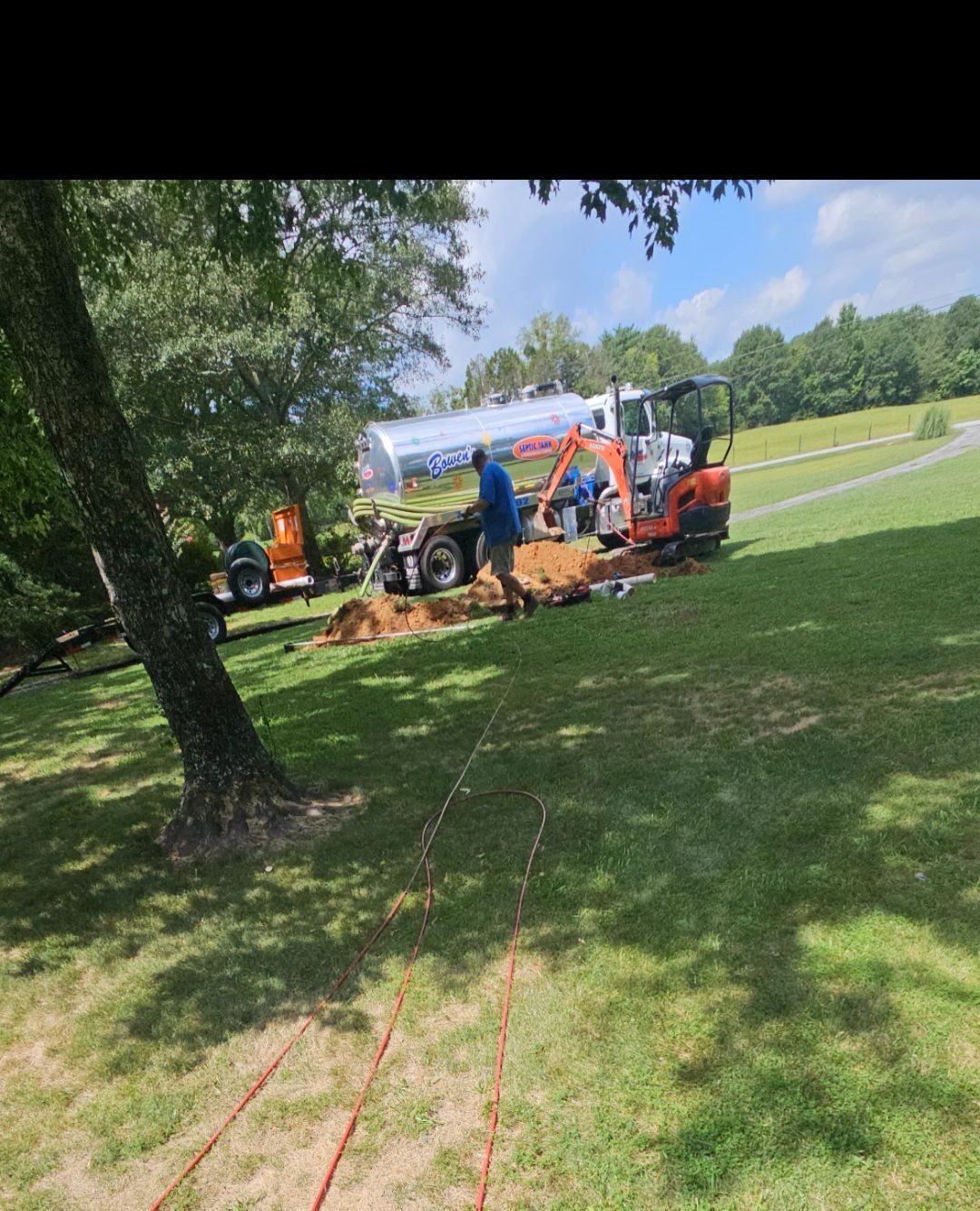 A man is digging a hole in the grass in a park.