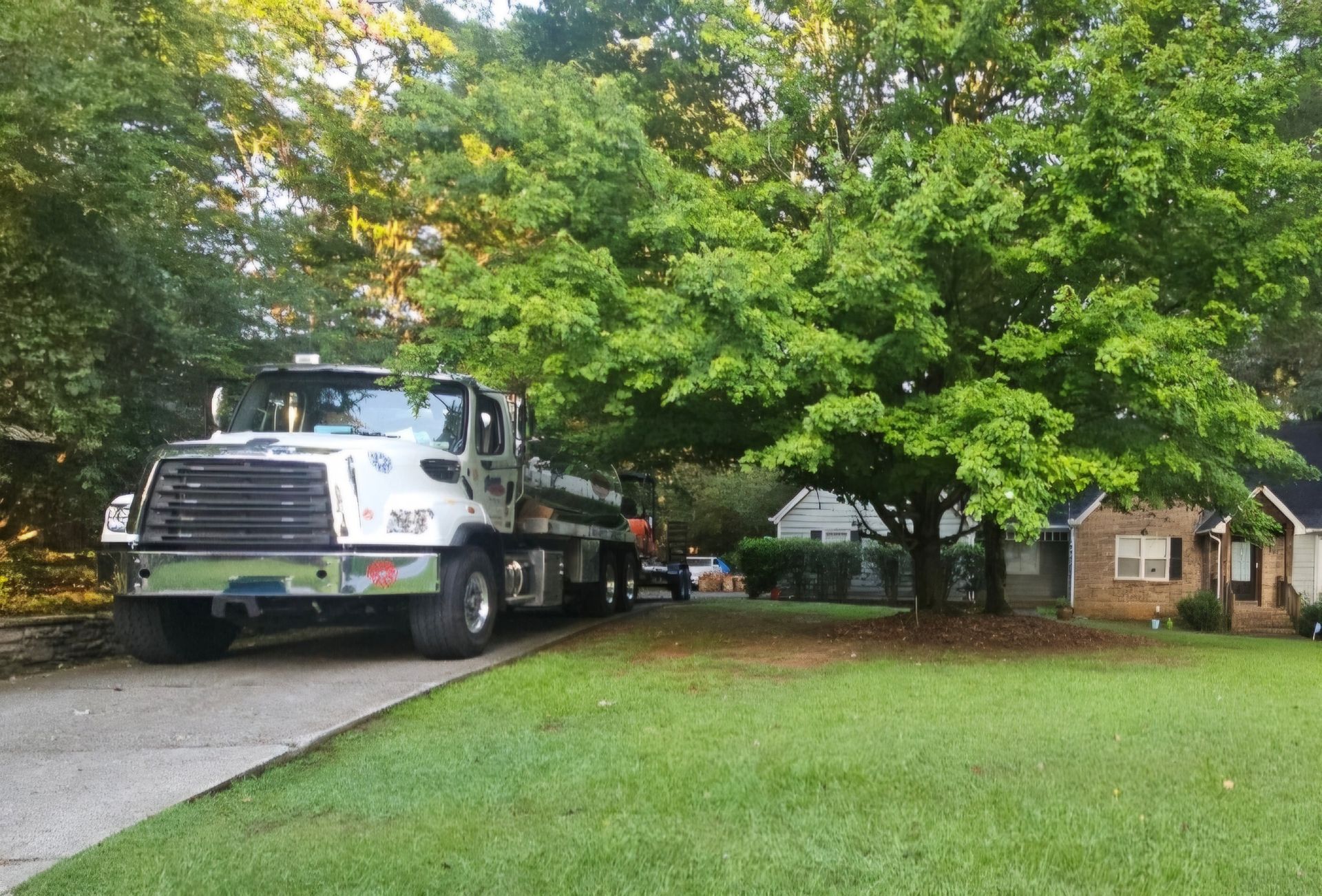 A truck is parked on the side of the road in front of a house.