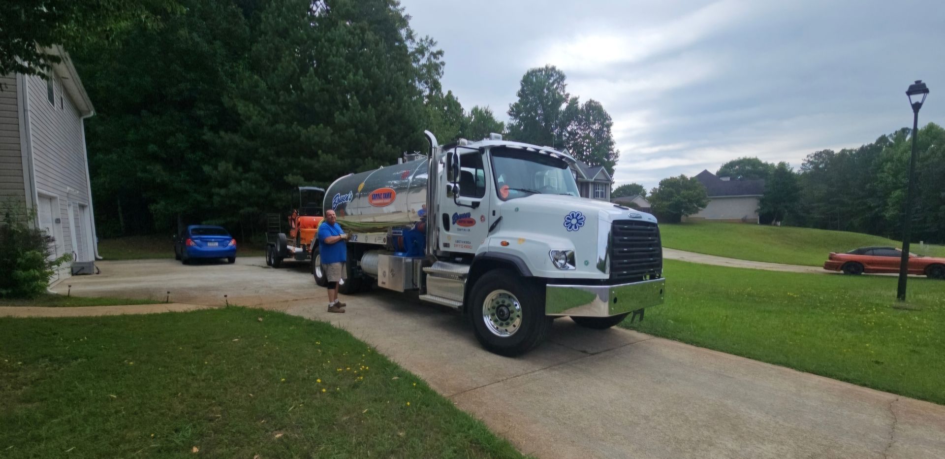 A white truck is parked in a driveway next to a house.