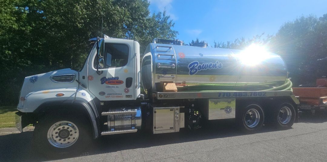 A septic tank truck is parked on the side of the road.