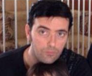 A man in a black shirt is holding a child in his arms.
