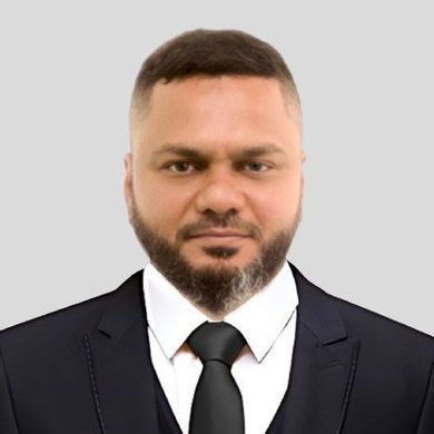 A man with a beard is wearing a suit and tie.