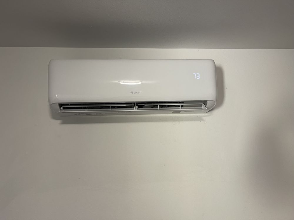 White wall-mounted air conditioner unit displaying 73 degrees.