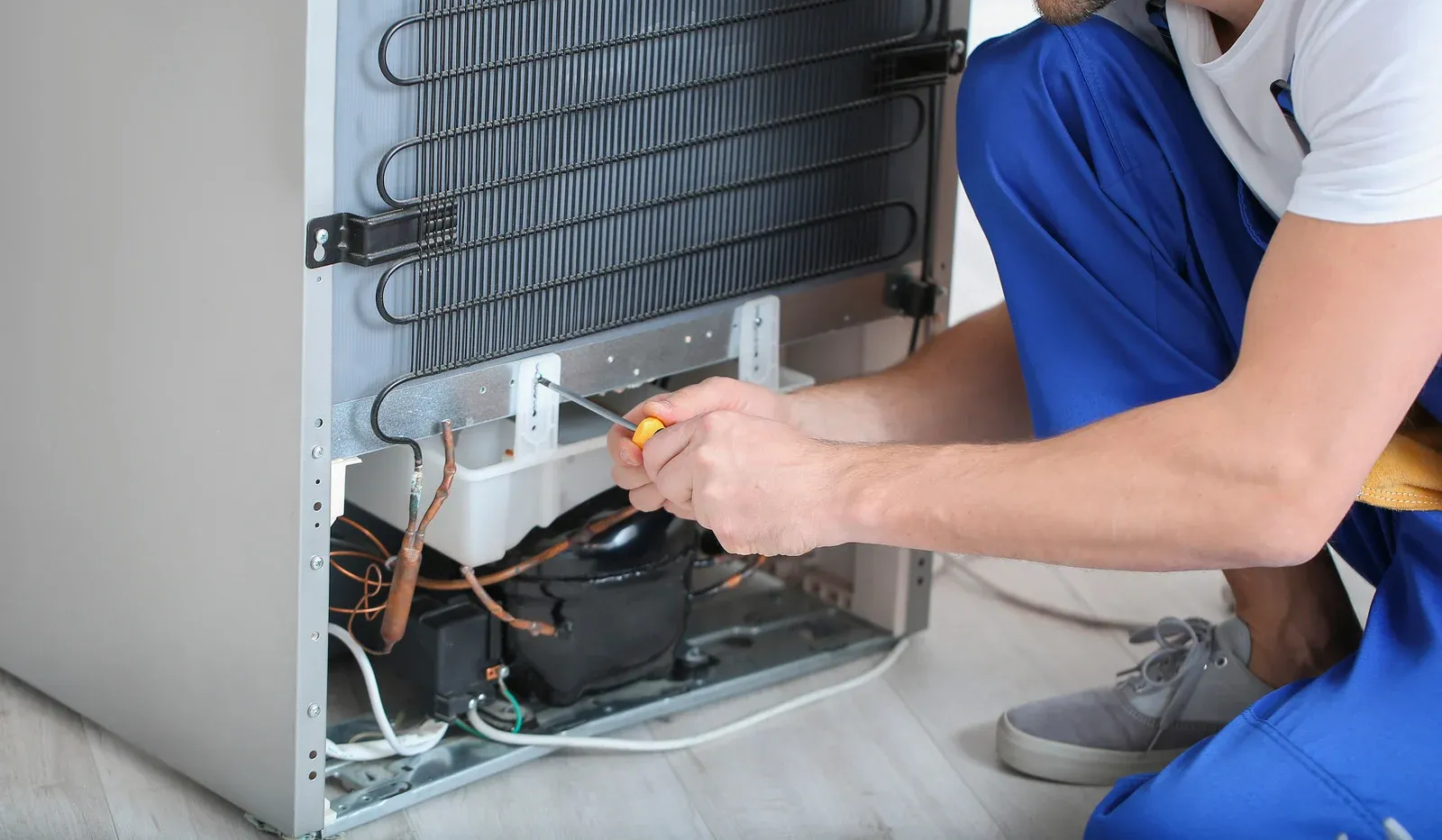 A man wearing a hard hat and goggles is standing in a room.