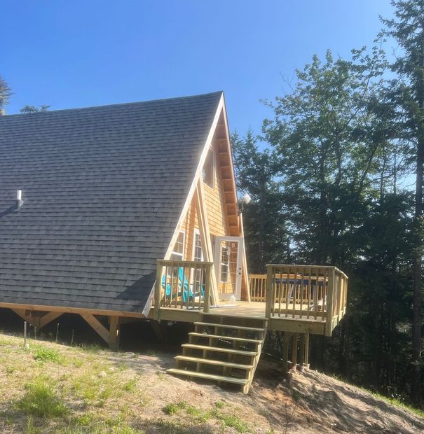 A house with a black roof and a wooden deck