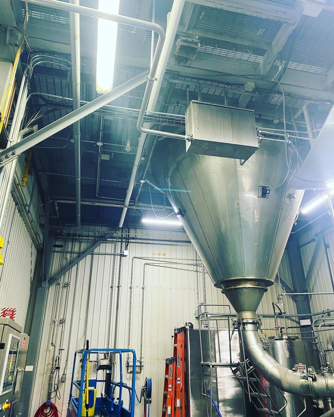 Un grand cône métallique se trouve au milieu d'une usine.