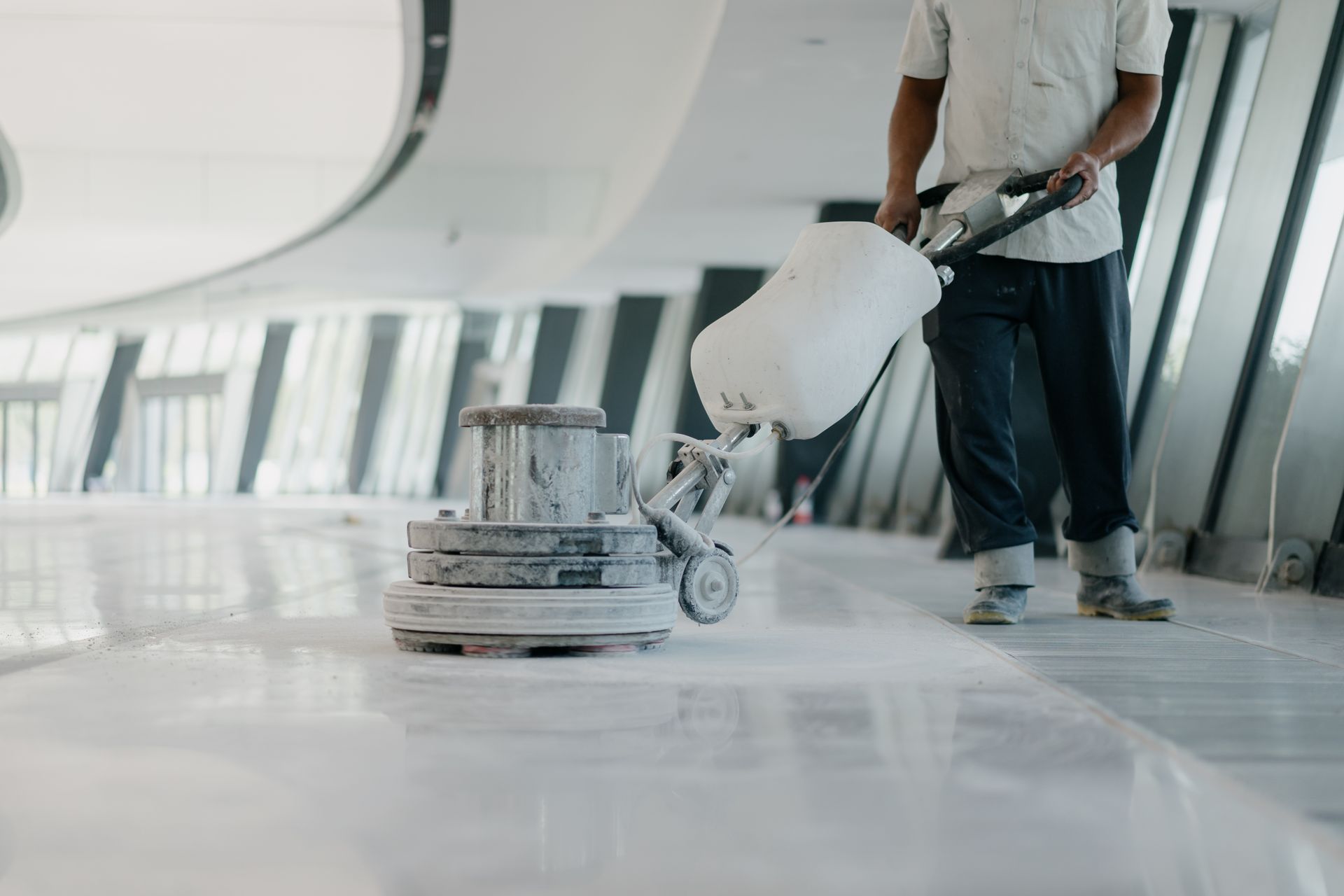 Un homme nettoie un sol en marbre avec une machine.