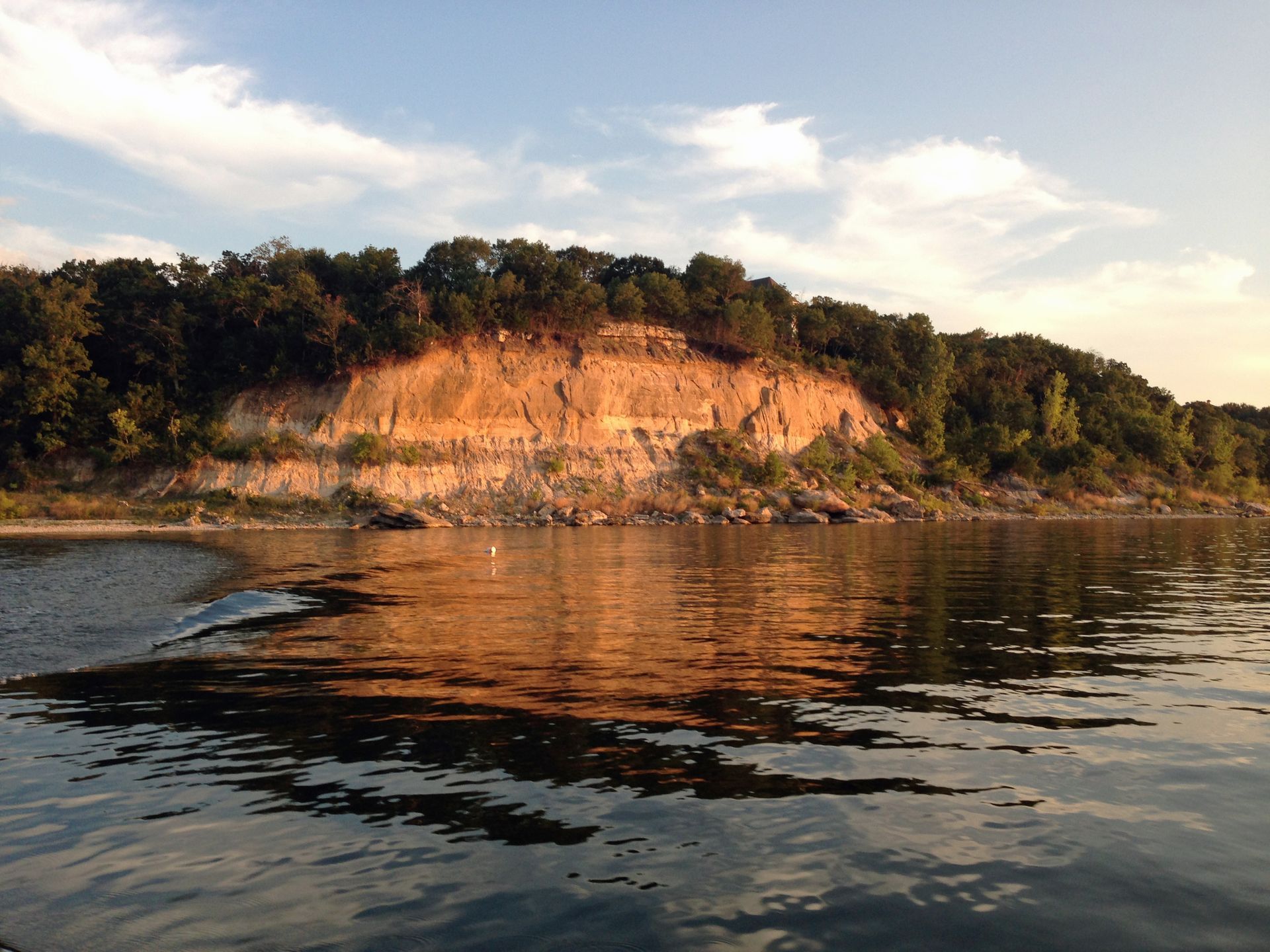 A large body of water with a cliff in the background