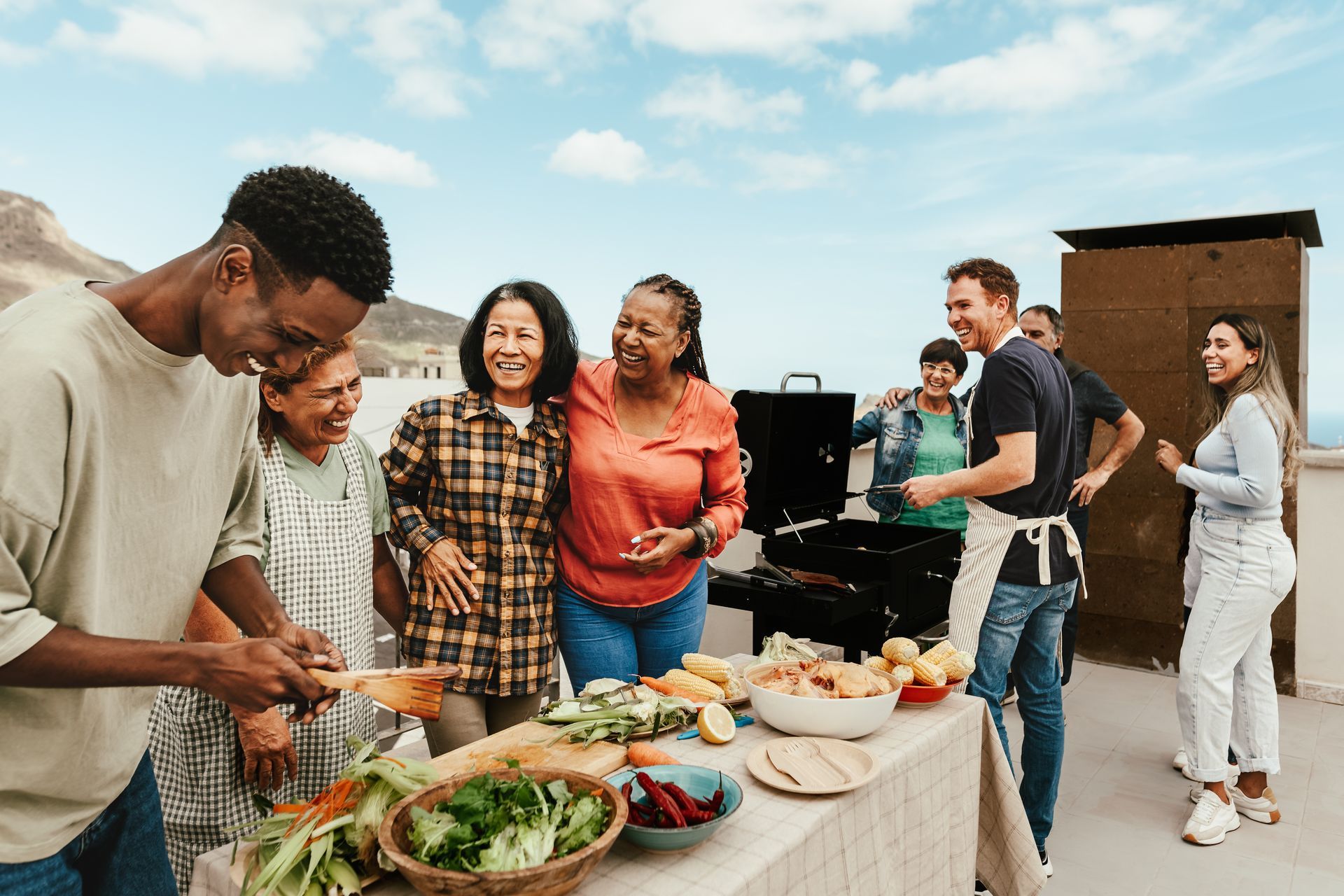 A group of people are standing around a table cooking food.