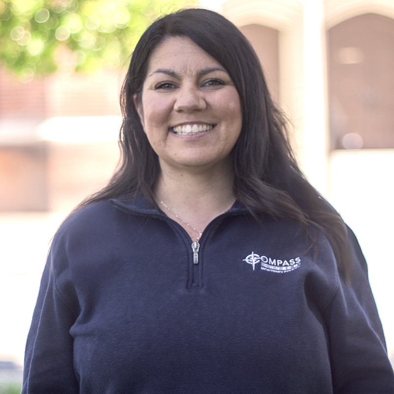 Woman smiling, wearing a navy sweatshirt with 
