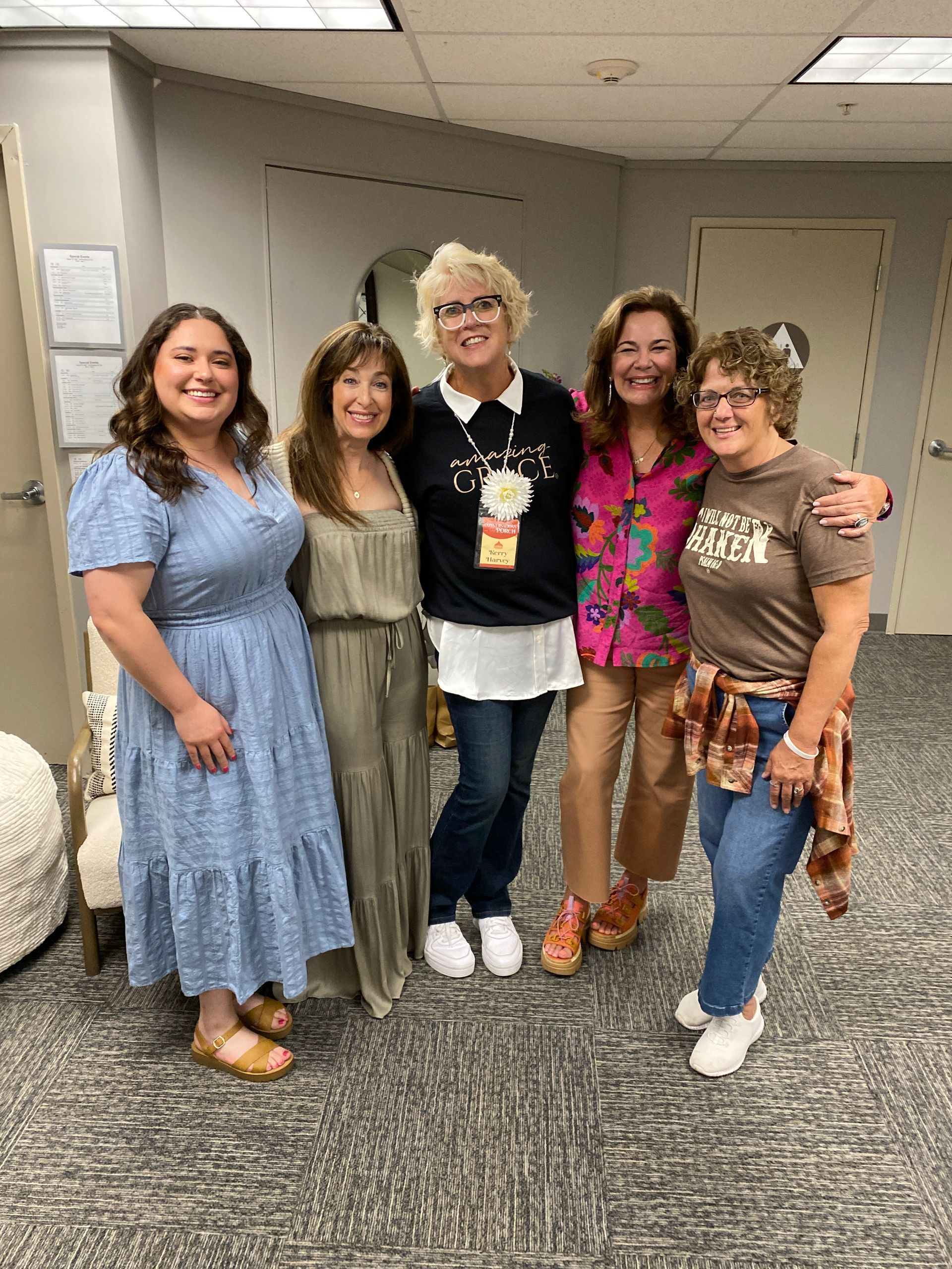 Audience in a large church watches a performance on stage with screens.