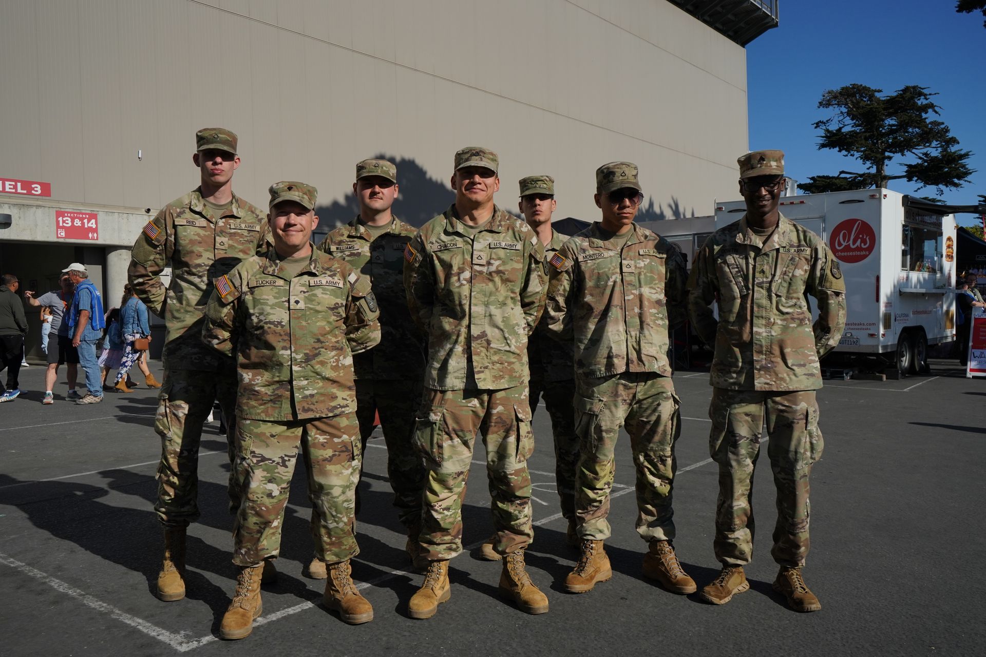 Group of uniformed soldiers posing for a photo outdoors.