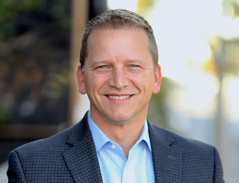 Audience in a large church watches a performance on stage with screens.
