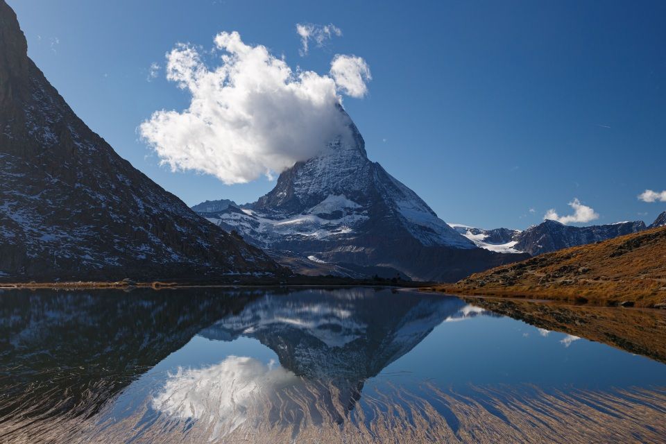 Mountain covered in snow by a river