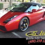 A red sports car is parked in a parking lot.