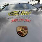 A close up of a porsche logo on the hood of a car.