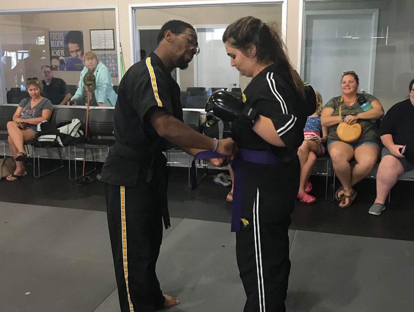 a man is giving a woman a purple belt