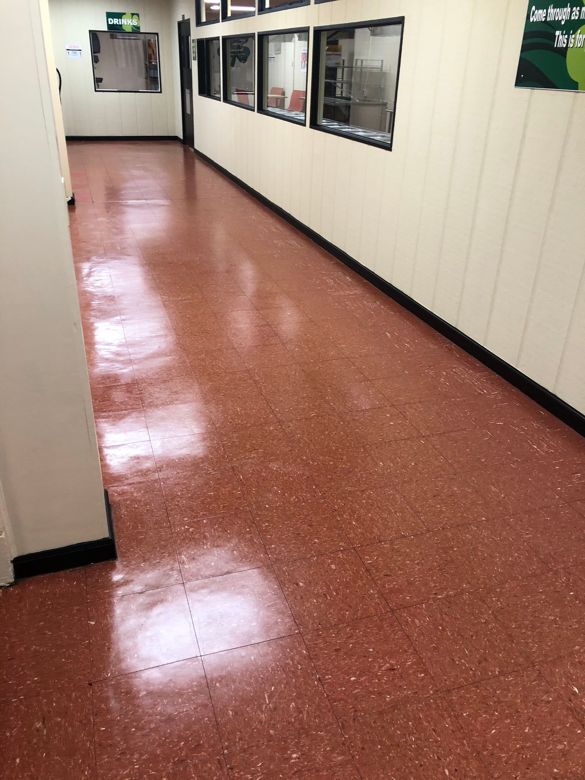 A long hallway with red speckled flooring.
