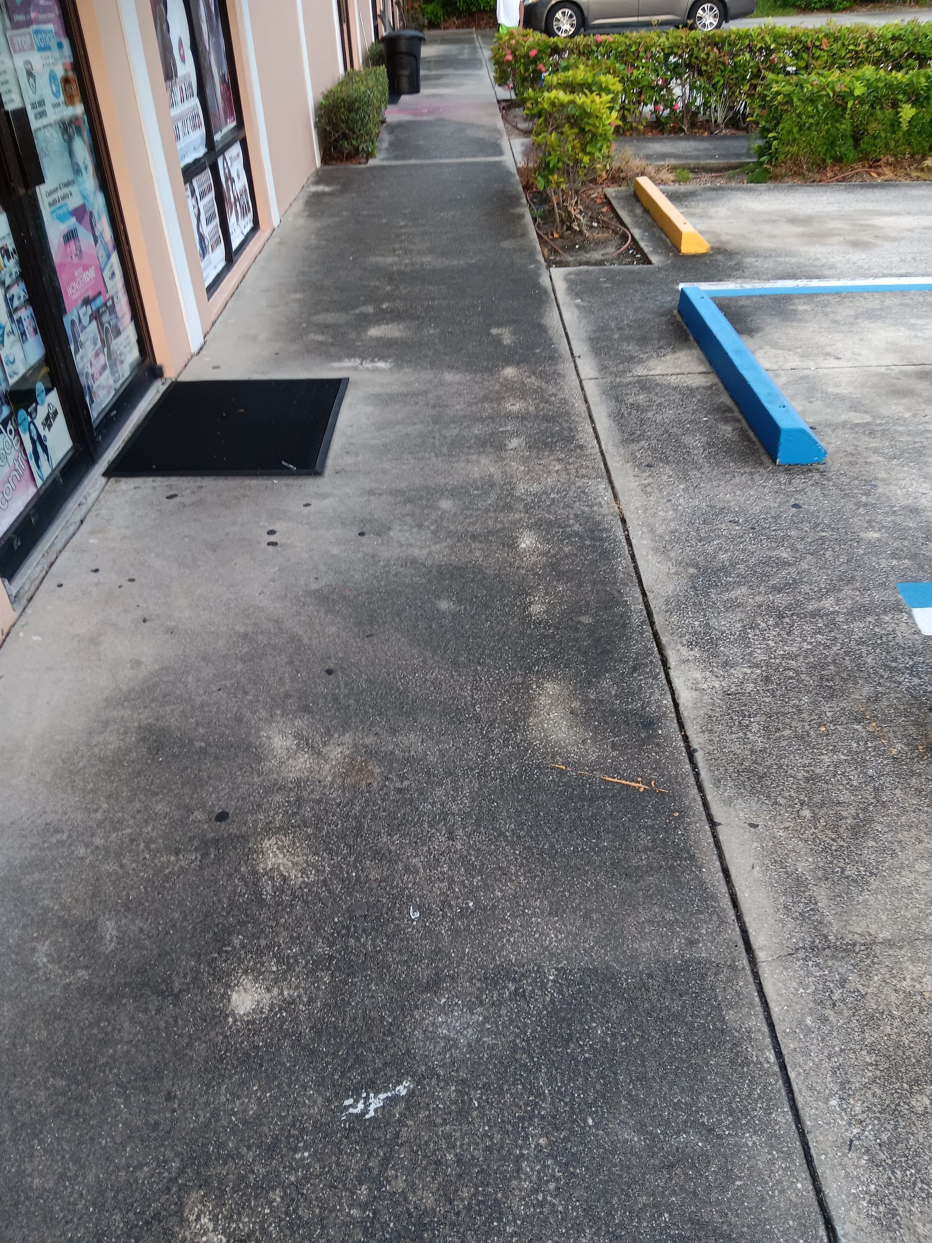 A sidewalk next to a parking lot with a handicapped parking space.