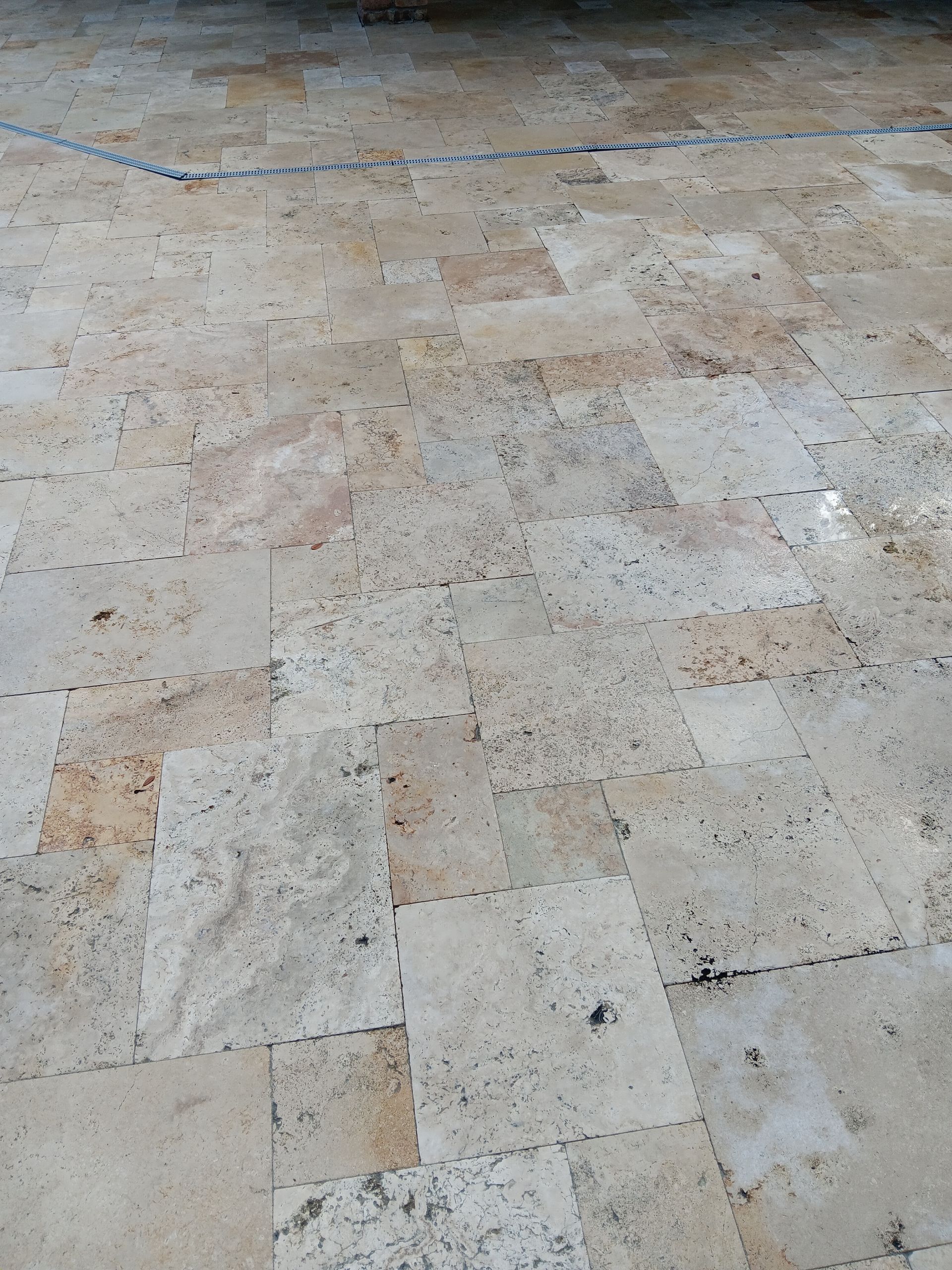 A close up of a tiled floor with a blue line going through it