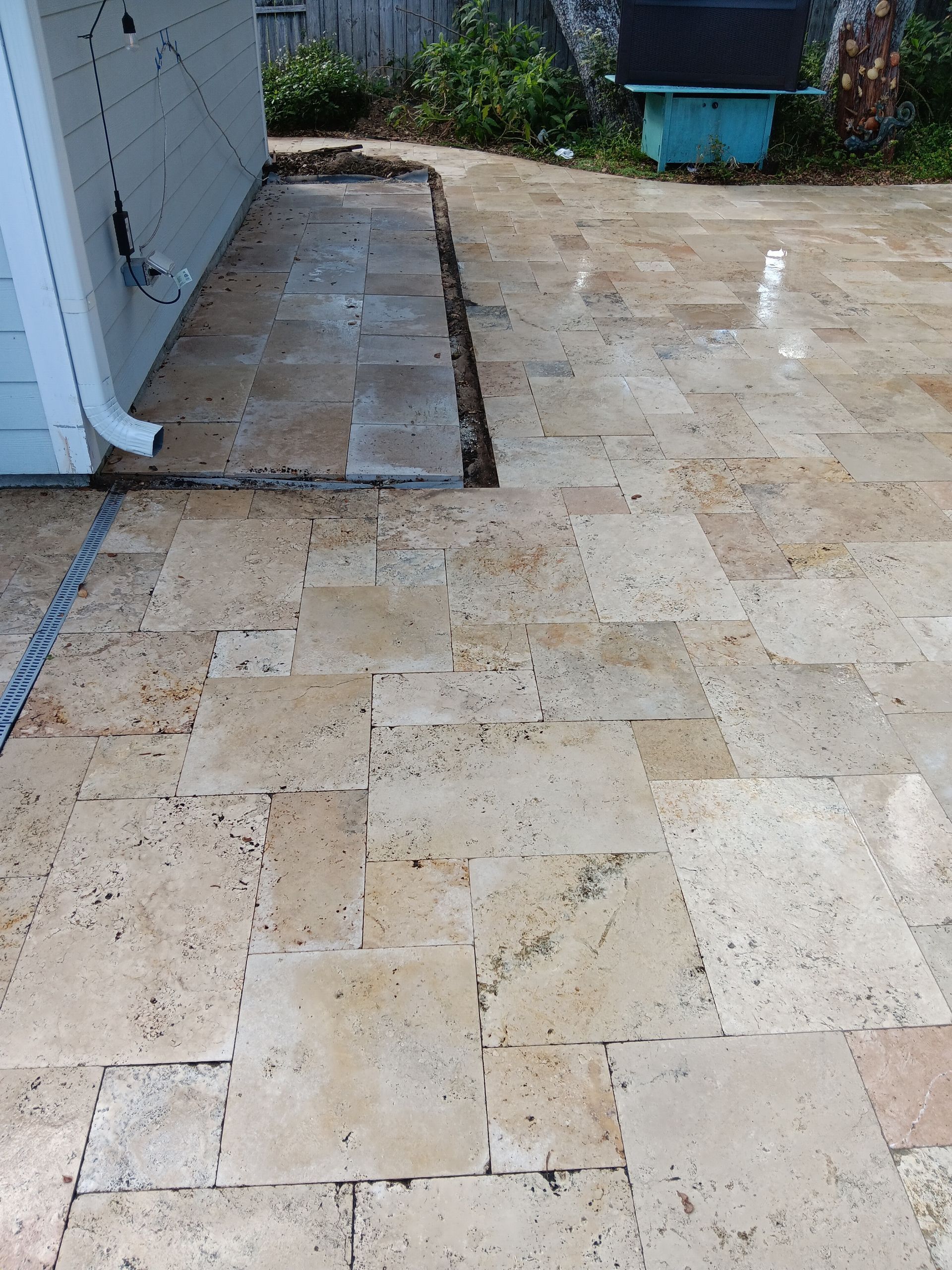 A patio with tiles and a drainpipe next to a house