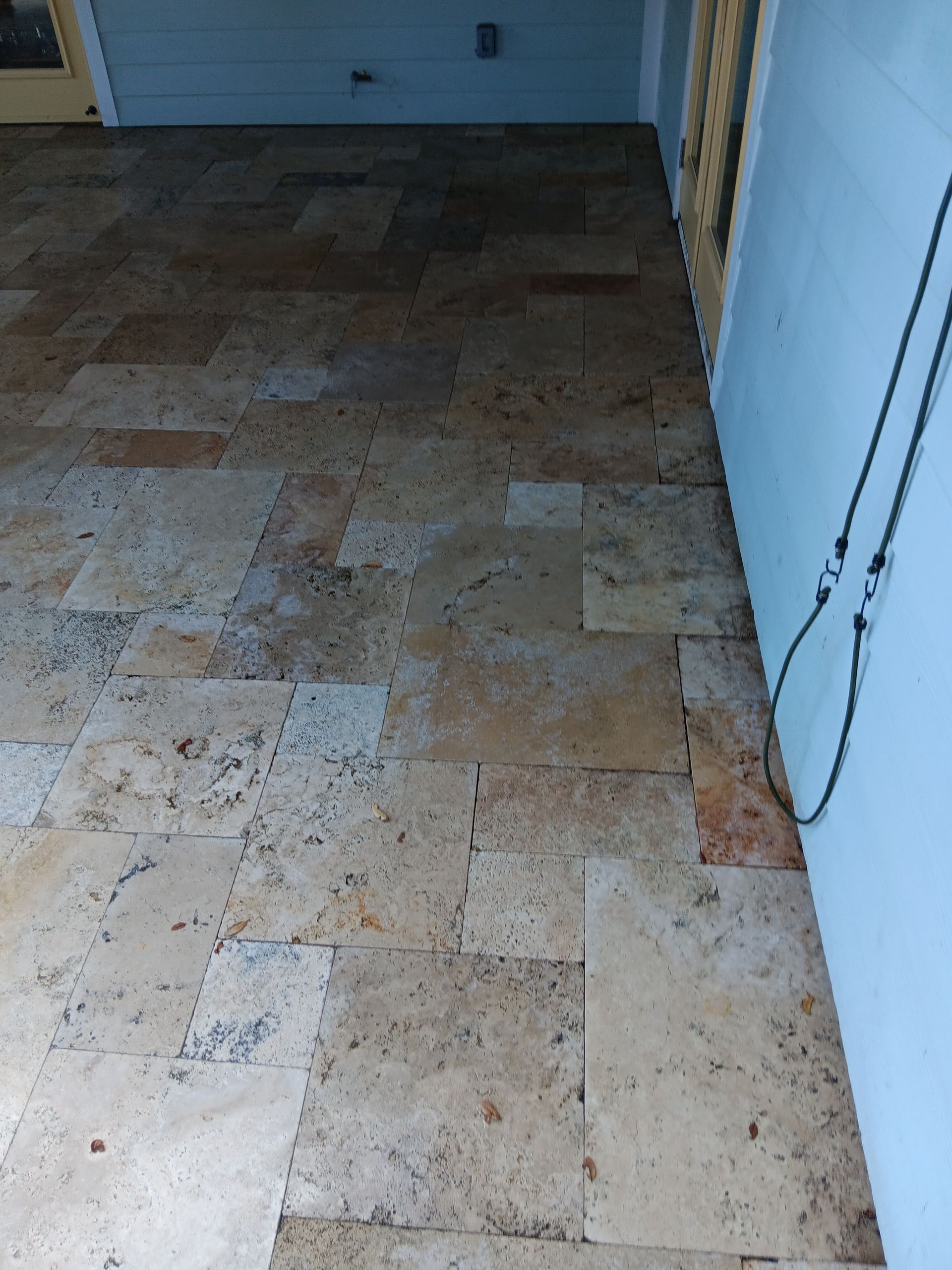 A tiled floor in a room with a blue wall