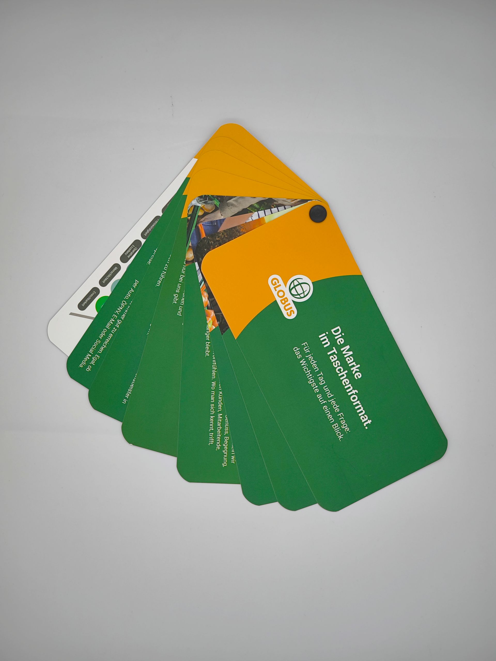 Ein Stapel grüner und gelber Visitenkarten mit einer Fremdsprache darauf