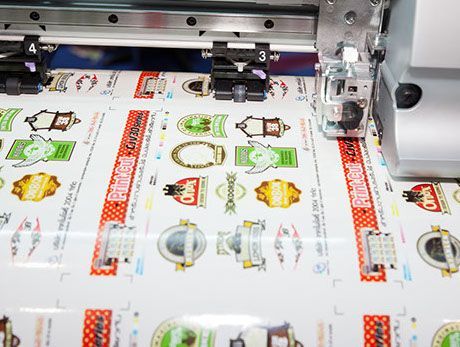 Eine Maschine druckt Aufkleber auf ein Blatt Papier.