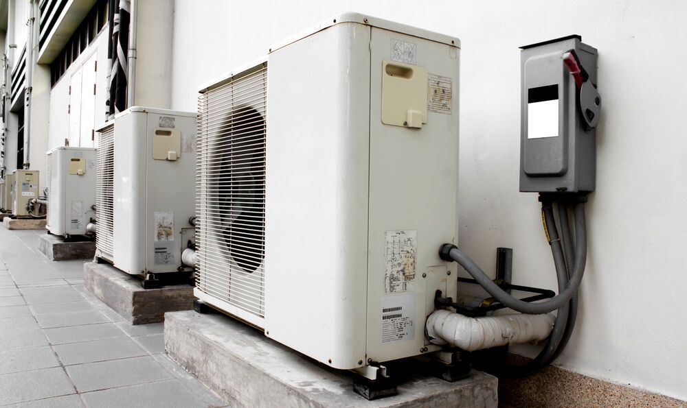 A Row of Air Conditioners Sit on the Side of a Building — Refrigerated Technologies (QLD) Pty Ltd In Cannonvale, QLD