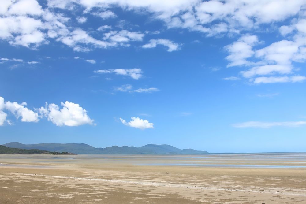 A Beach with Mountains in the Background and a Blue Sky with Clouds — Refrigerated Technologies (QLD) Pty Ltd In Cannonvale, QLD