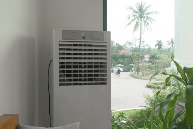 A White Air Conditioner is Sitting in a Room Next to a Window — Refrigerated Technologies (QLD) Pty Ltd In Bowen, QLD