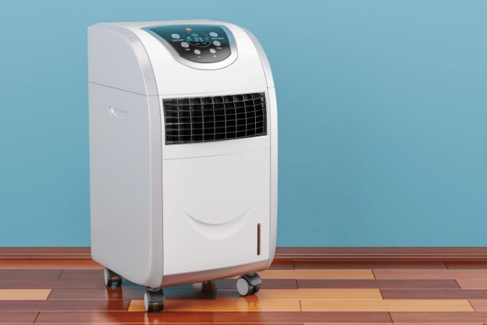 A Portable Air Conditioner is Sitting on a Wooden Floor in a Room — Refrigerated Technologies (QLD) Pty Ltd In Bowen, QLD
